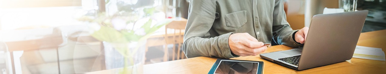 customer with laptop holding credit card