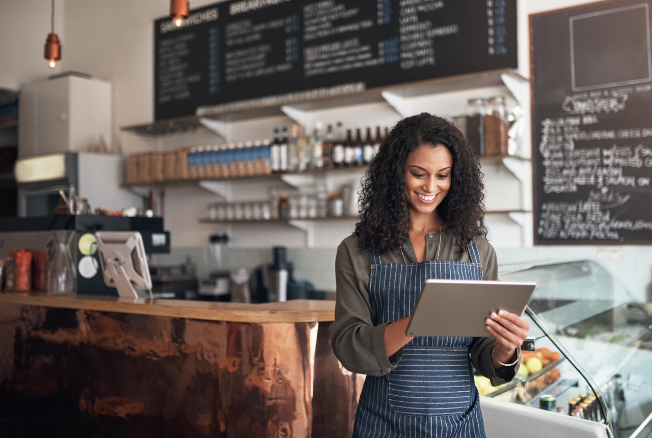 Shot of a young woman using a digital tablet while working in a cafe